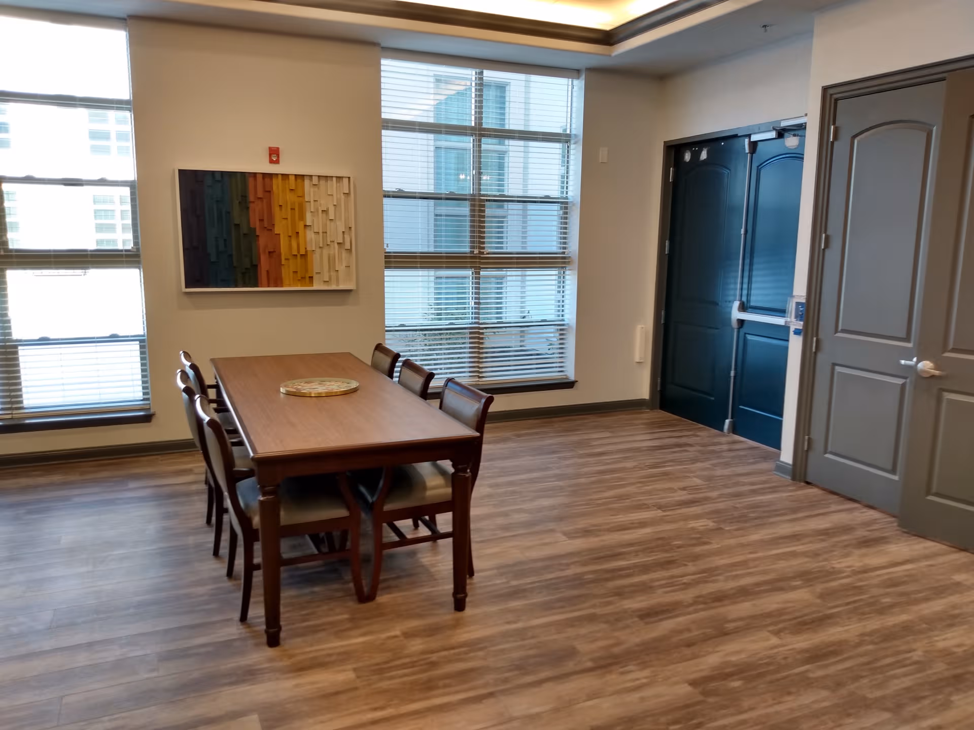 Dining room with a wooden table, chairs, and large windows.