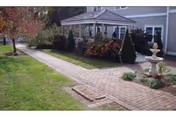 Front exterior of Apple Rehab Laurel Woods facility with brick path, garden, and fountain.