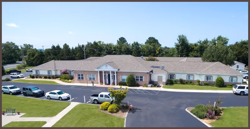 Exterior view of Carriage House Inn, a single-story senior living facility with parking.