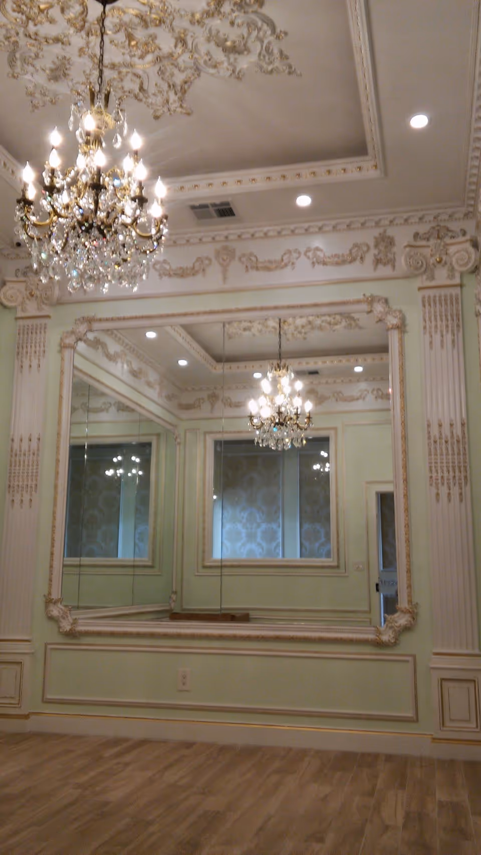 Elegant mirrored room with chandeliers and ornate walls in a senior facility.