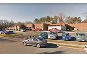Exterior view of Brookside Rehab & Nursing Center with parked cars in the lot.