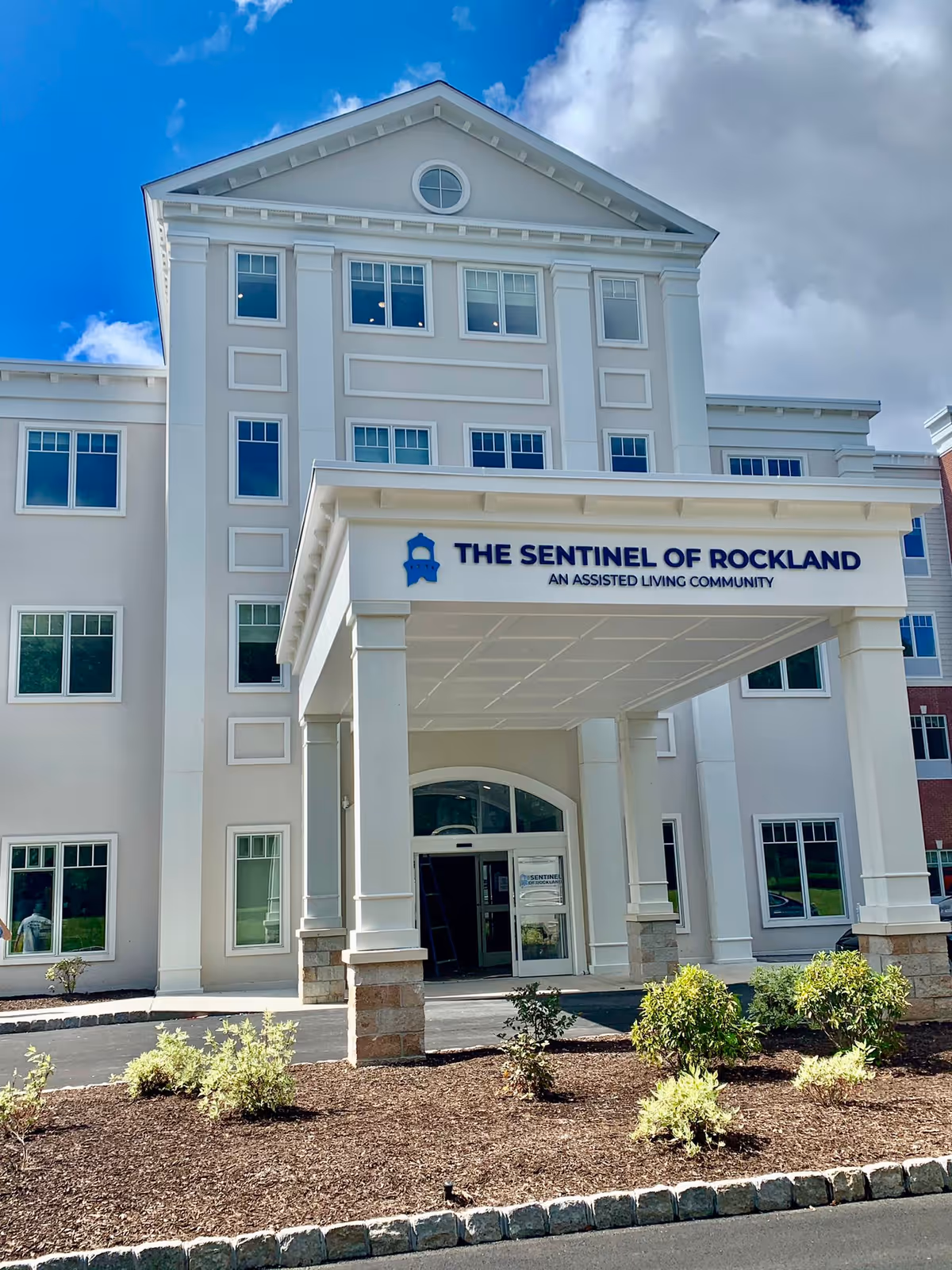 Exterior view of The Sentinel of Rockland assisted living facility and entrance.