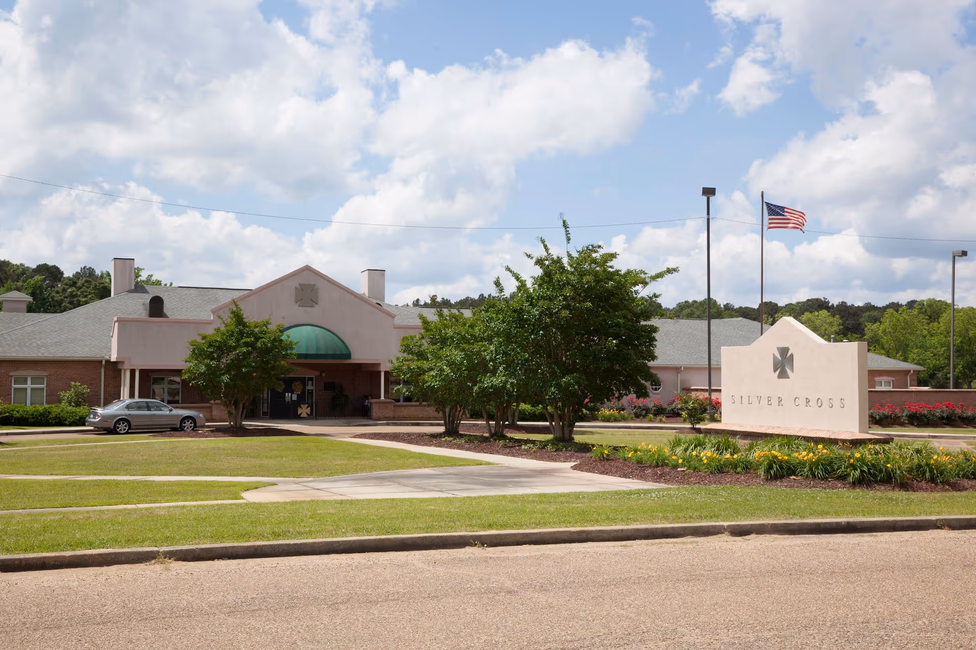 Exterior view of Silver Cross Health and Rehab with landscaped entrance and flag.