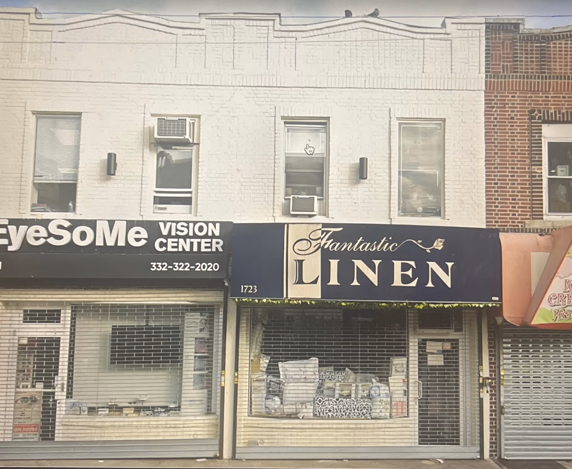 Two storefronts on a city street with EyeSoMe Vision Center and Fantastic Linen signage.