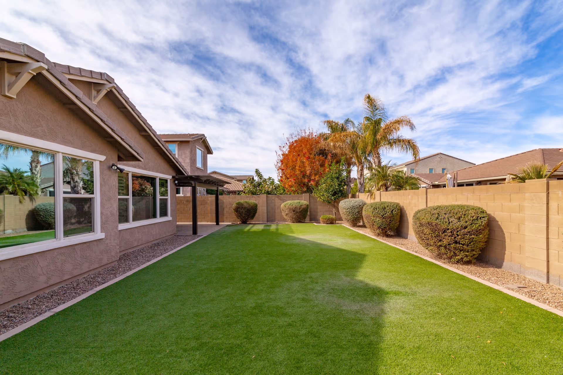 Well-kept outdoor area of a senior living home with green lawn and trimmed shrubs