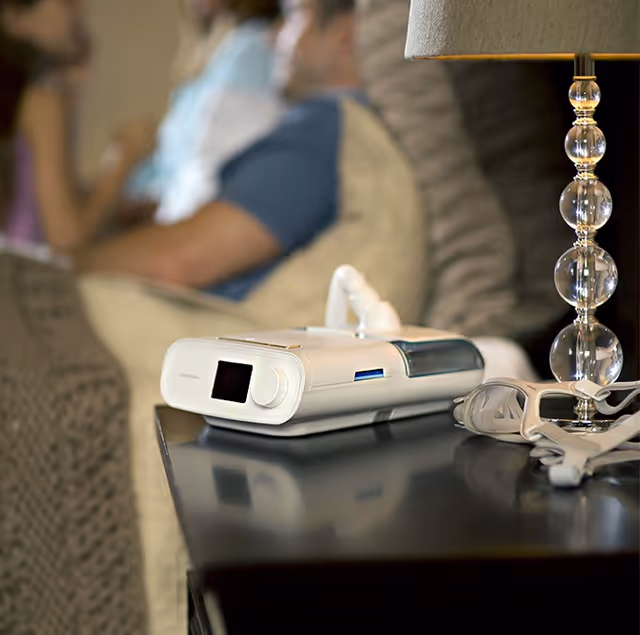 Portable monitoring device on a nightstand in a cozy living room.