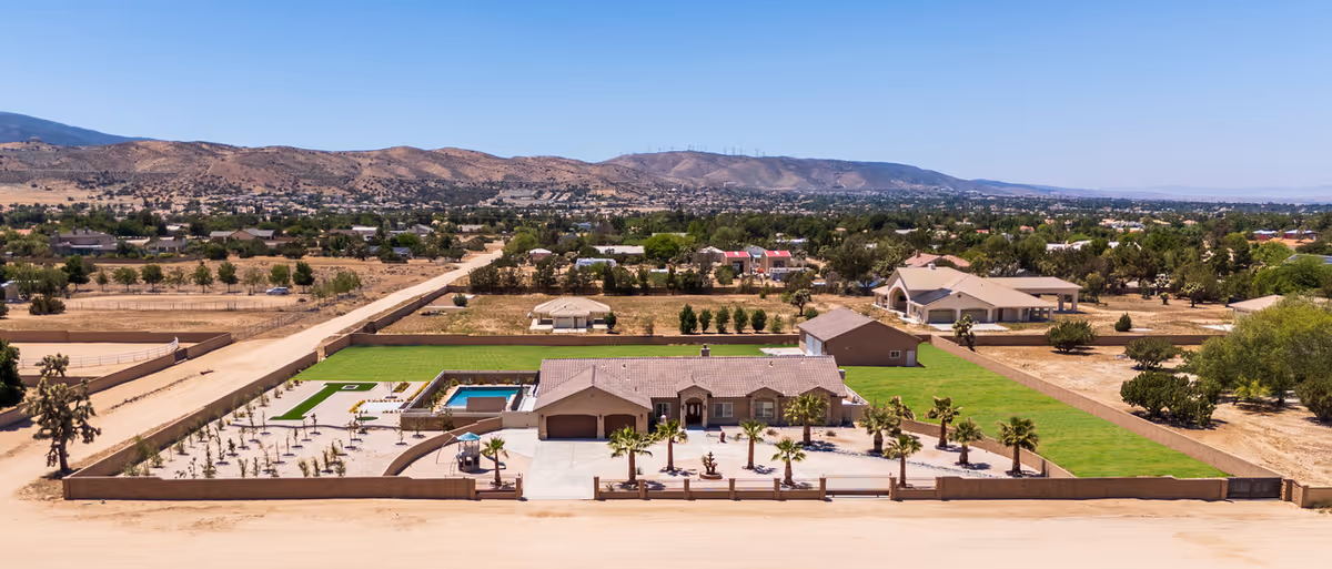 Aerial view of a single-story senior facility with pool and desert landscaping.