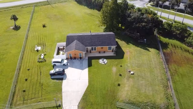 Aerial view of a single-story senior living facility with a green lawn and driveway.