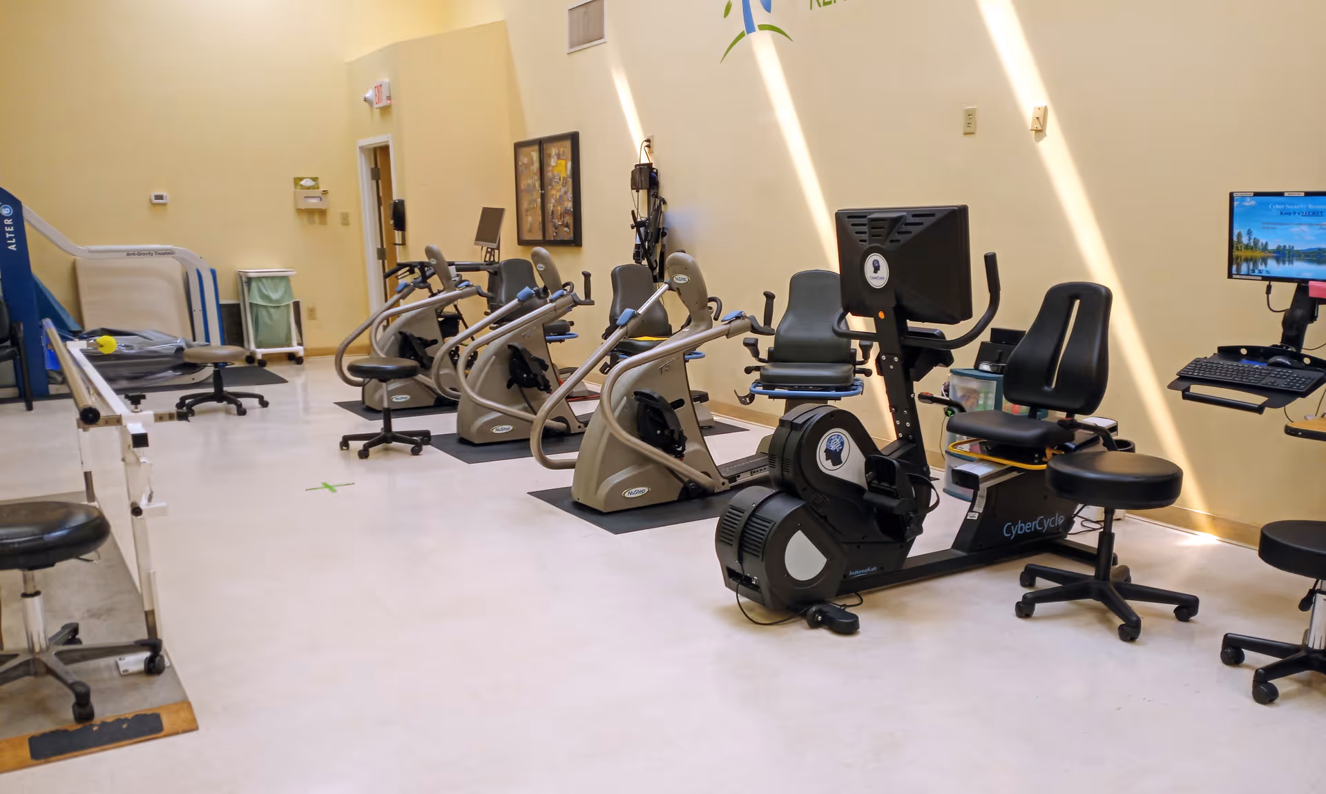 A senior living facility gym with cardio bikes and fitness equipment.
