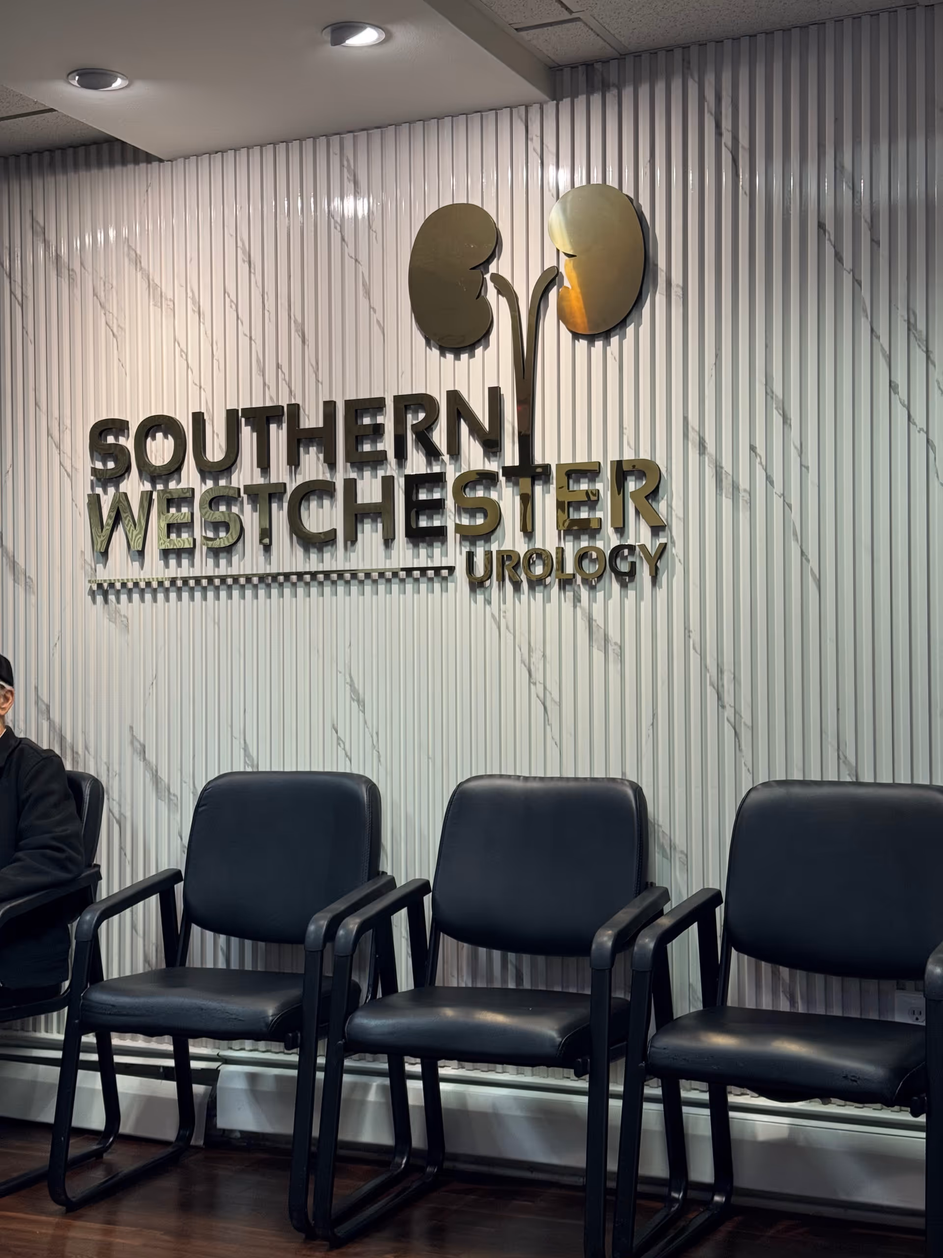 Lobby waiting area with black chairs and a Southern Westchester Urology sign.