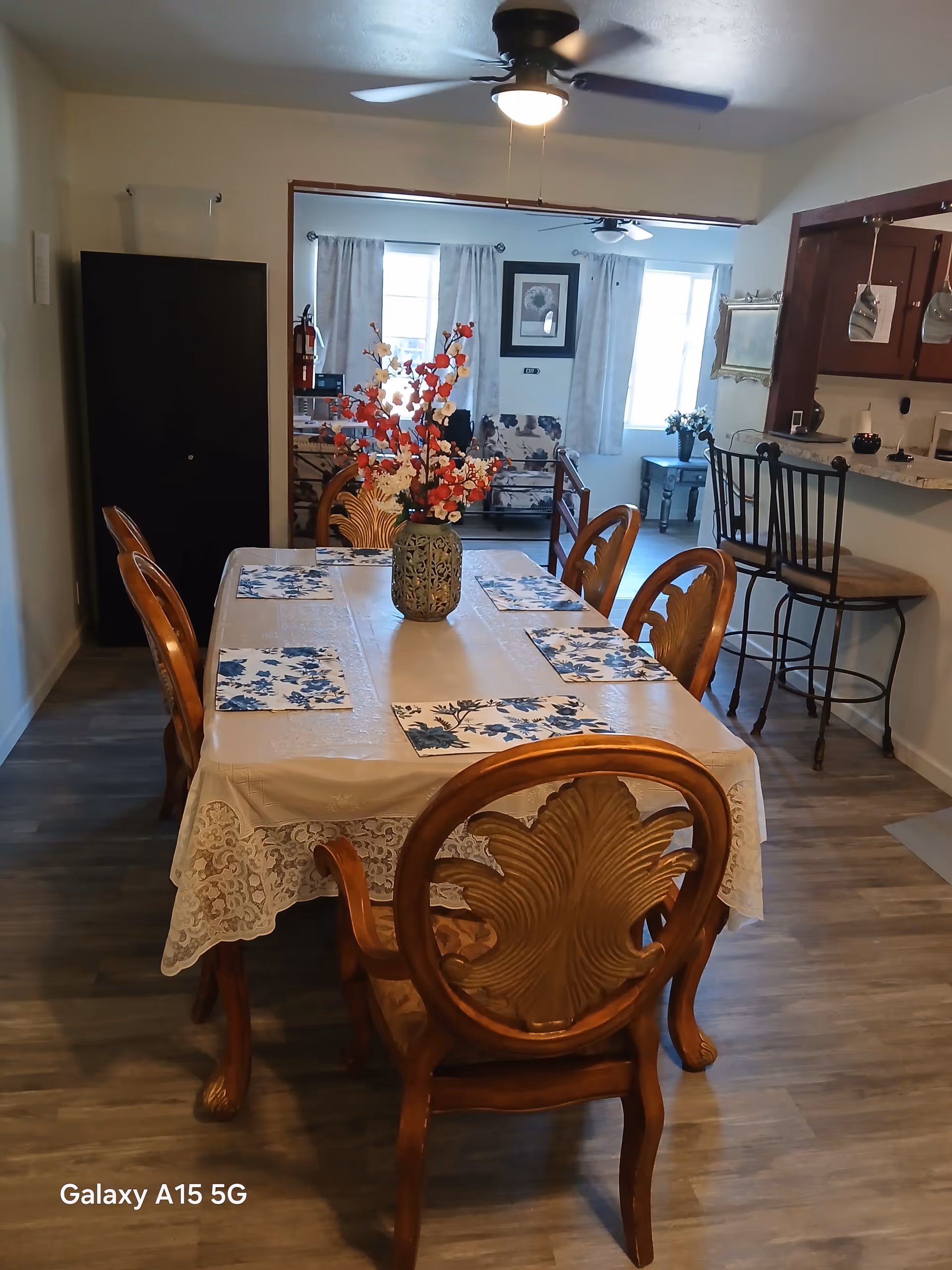 Dining room table set with blue floral placemats and a decorative centerpiece.