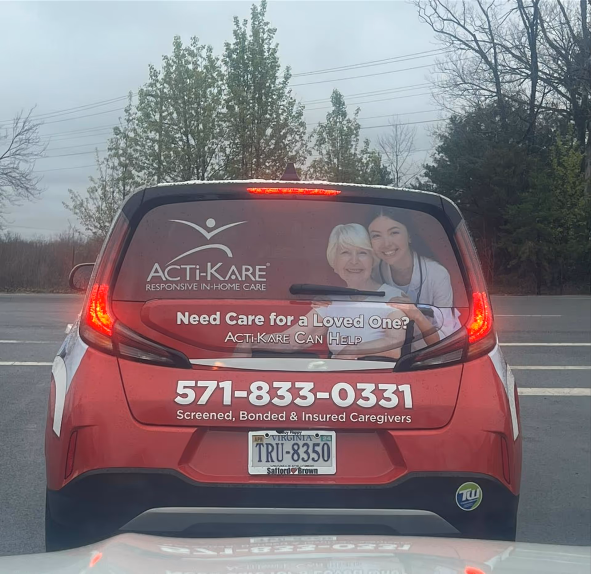 Red van rear displays Acti-Kare Senior & Home Care Arlington, VA advertisement.