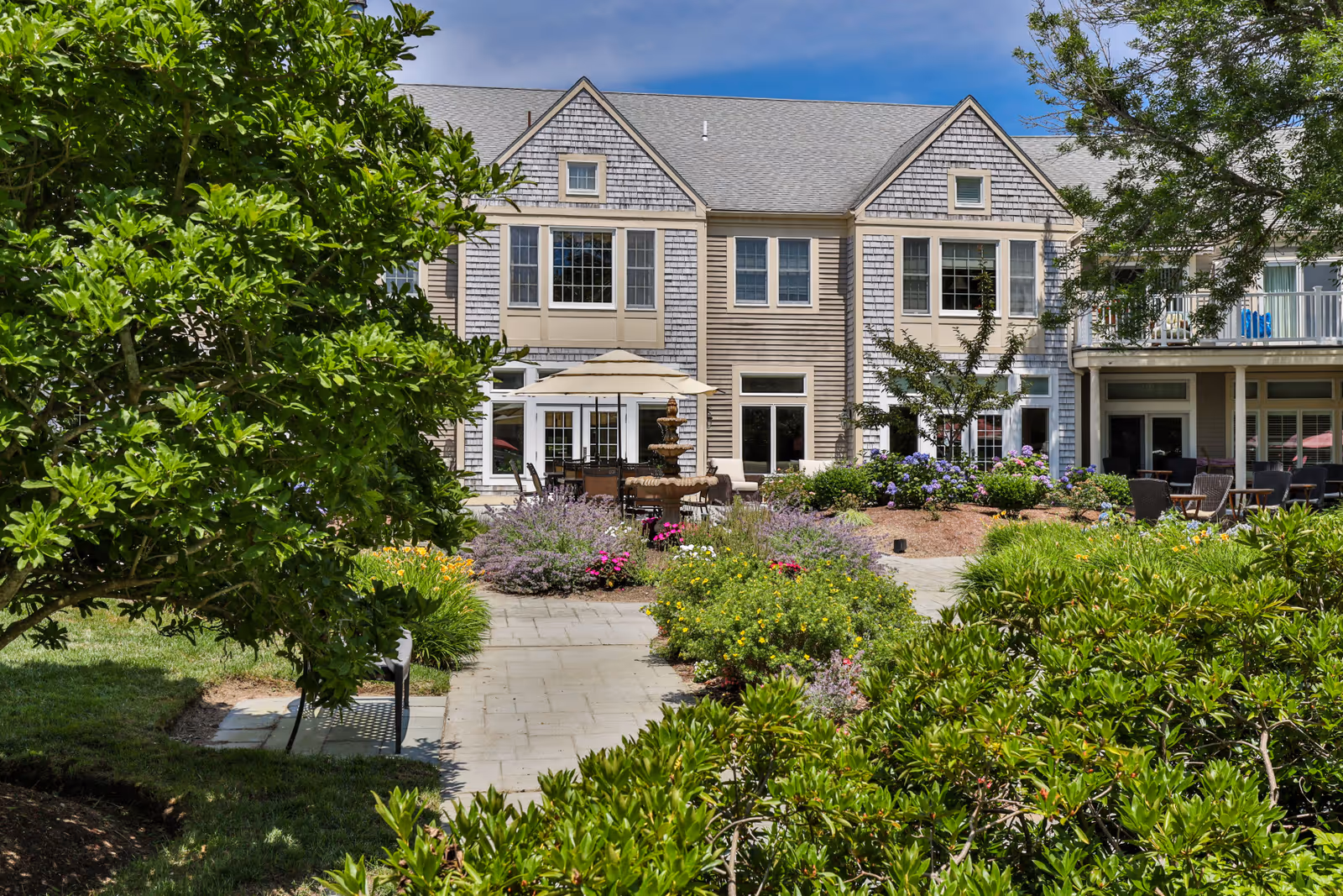 Heatherwood at Kings Way exterior with landscaped courtyard, patio seating, and garden surrounds.