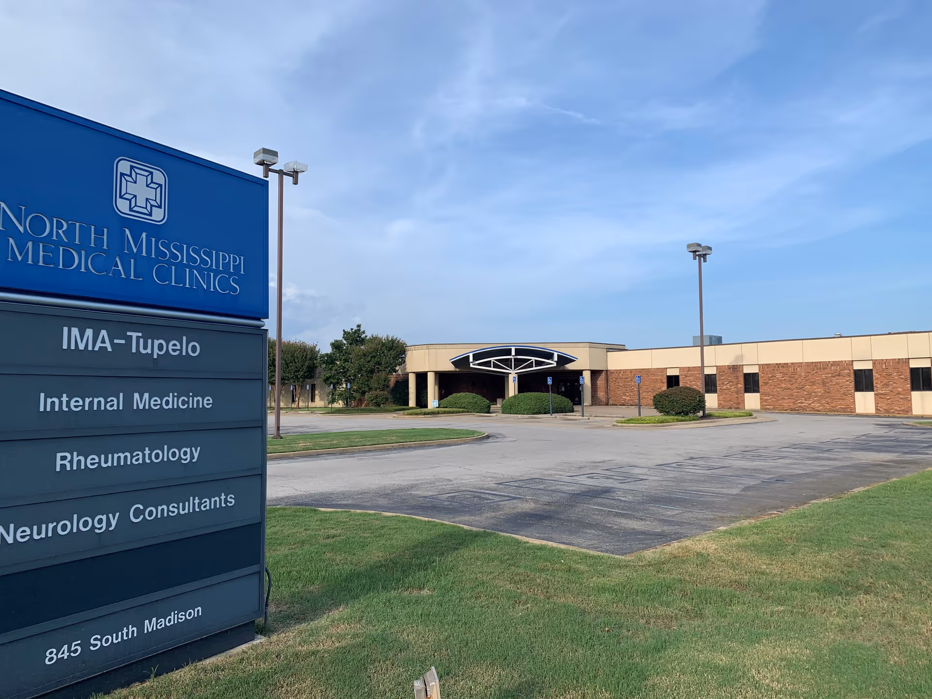 Front exterior of North Mississippi Medical Clinics building with parking lot.