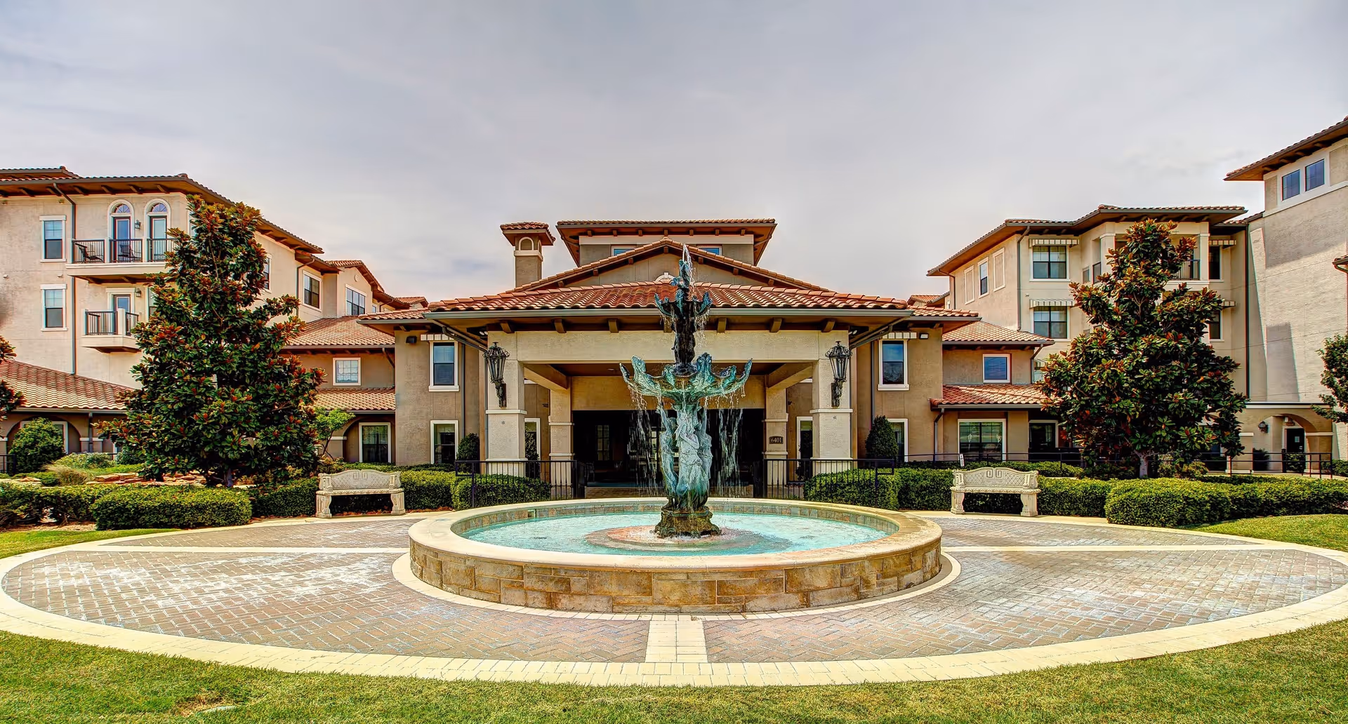 Front view of a senior living campus with a central fountain courtyard.