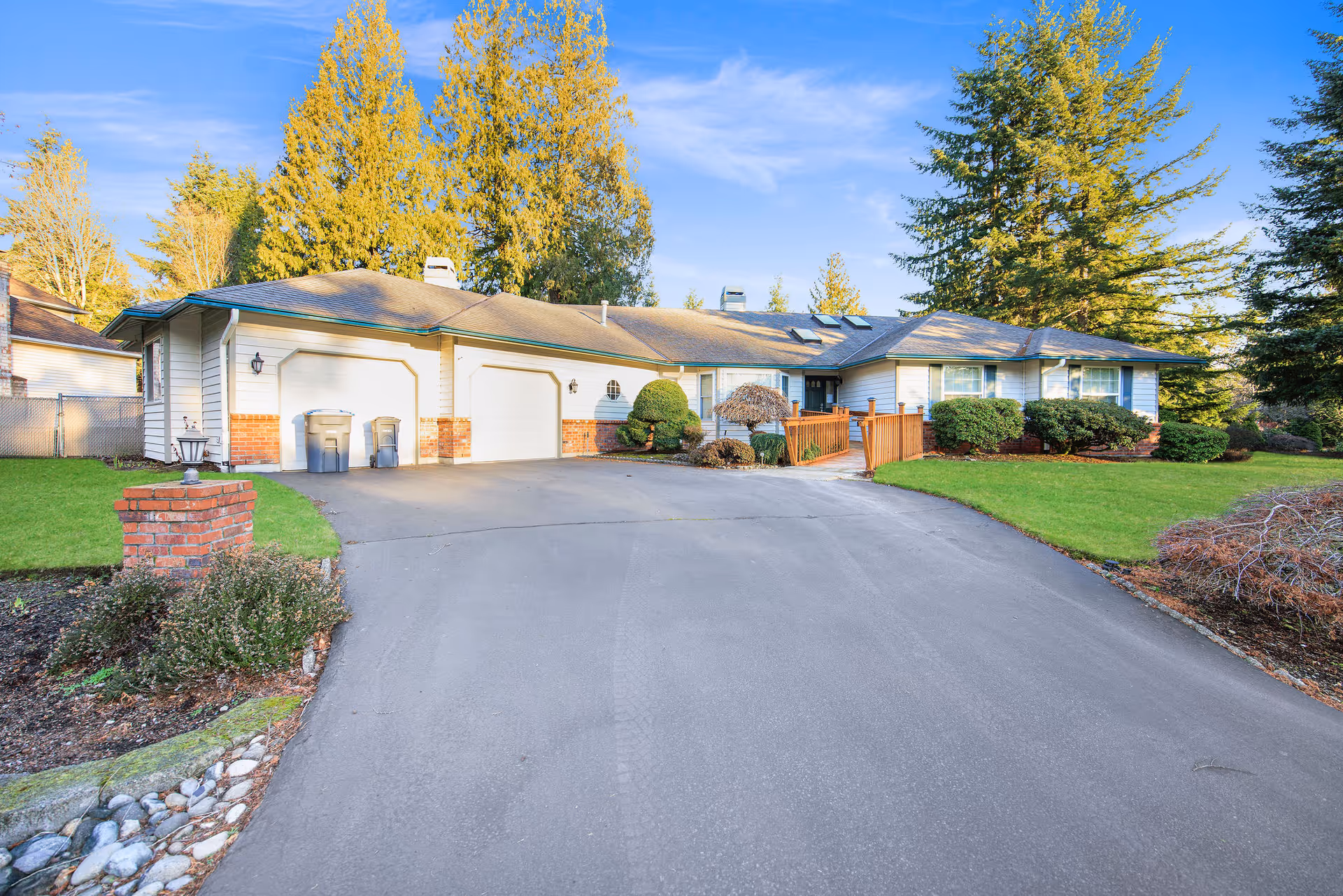 Single-story residential building with a circular driveway and manicured lawn, in a suburban setting.