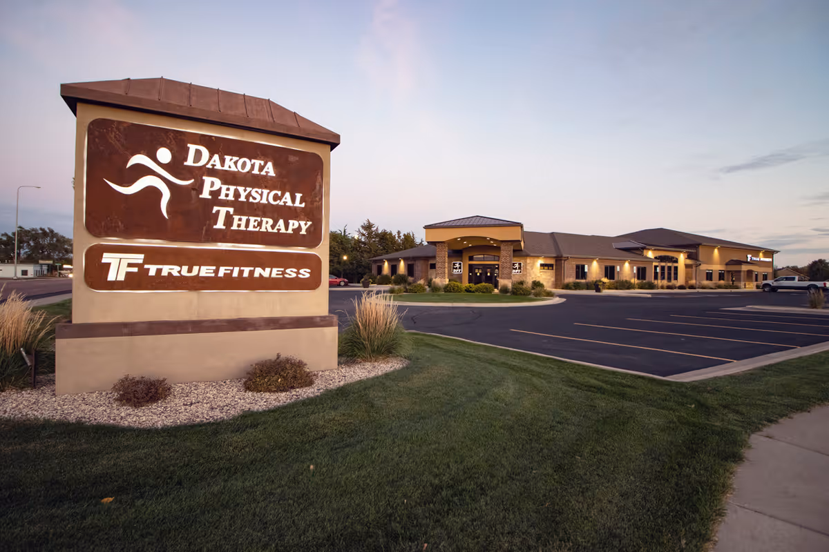 Dakota Physical Therapy sign with True Fitness at a single-story beige brick building.