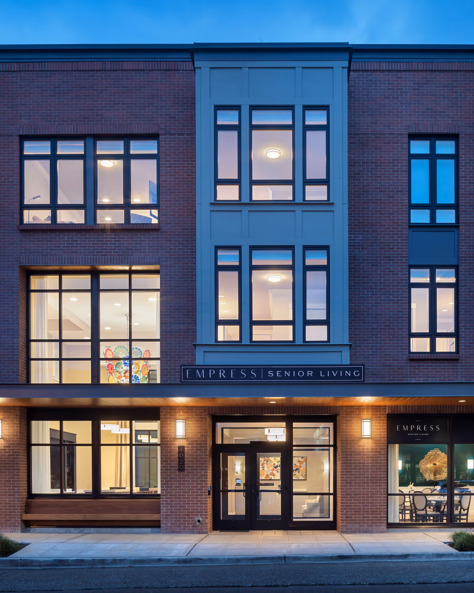 Exterior view of Empress Senior Living at Laurelhurst with large front windows.