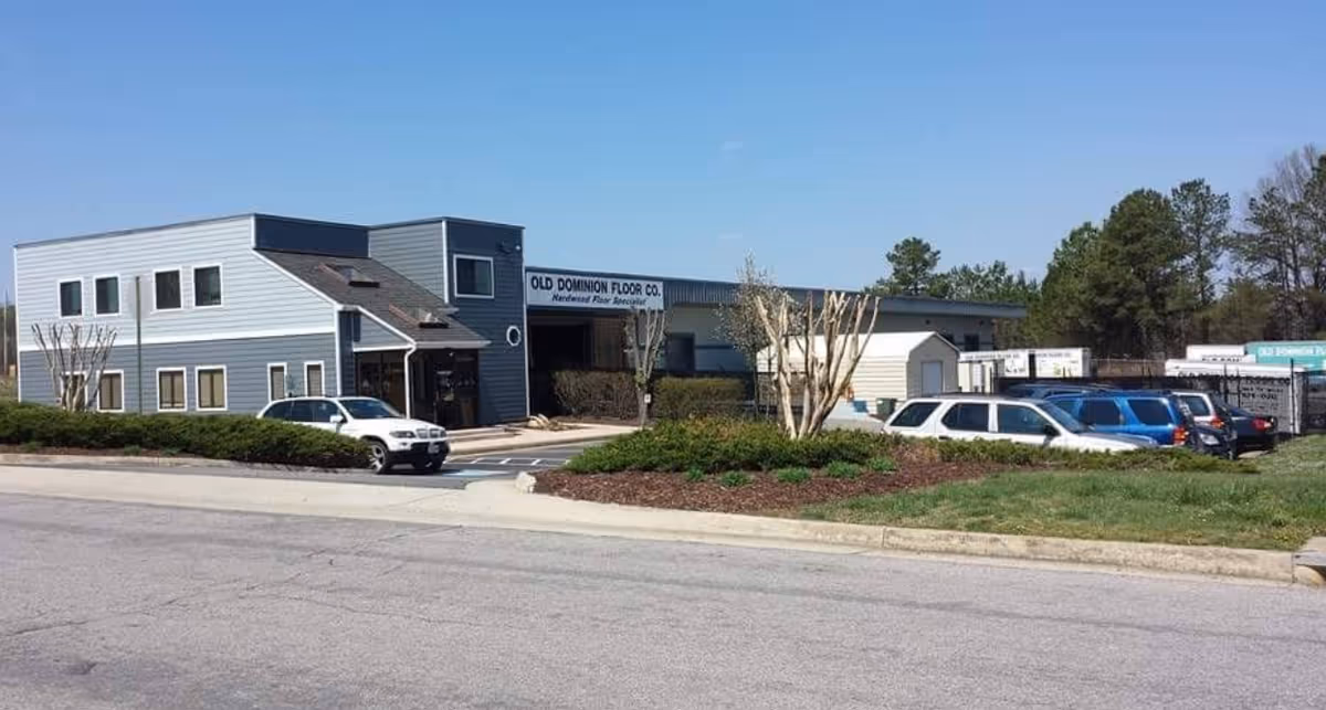 Exterior view of a modern office building with a parking lot and landscaping.