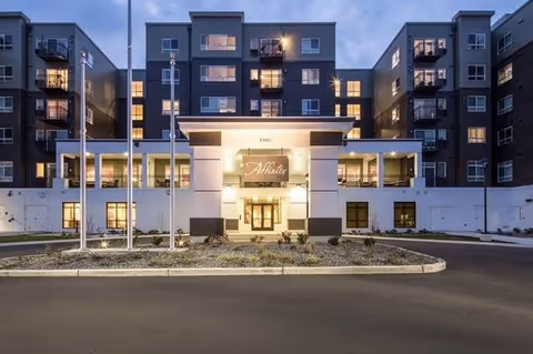 Exterior view of Affinity at Covington building with illuminated entrance and landscaping.