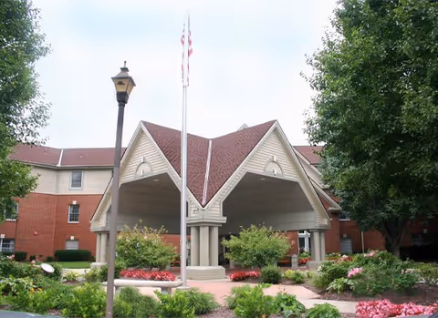 Front entrance of The Forum at Overland Park with flagpole and landscaping