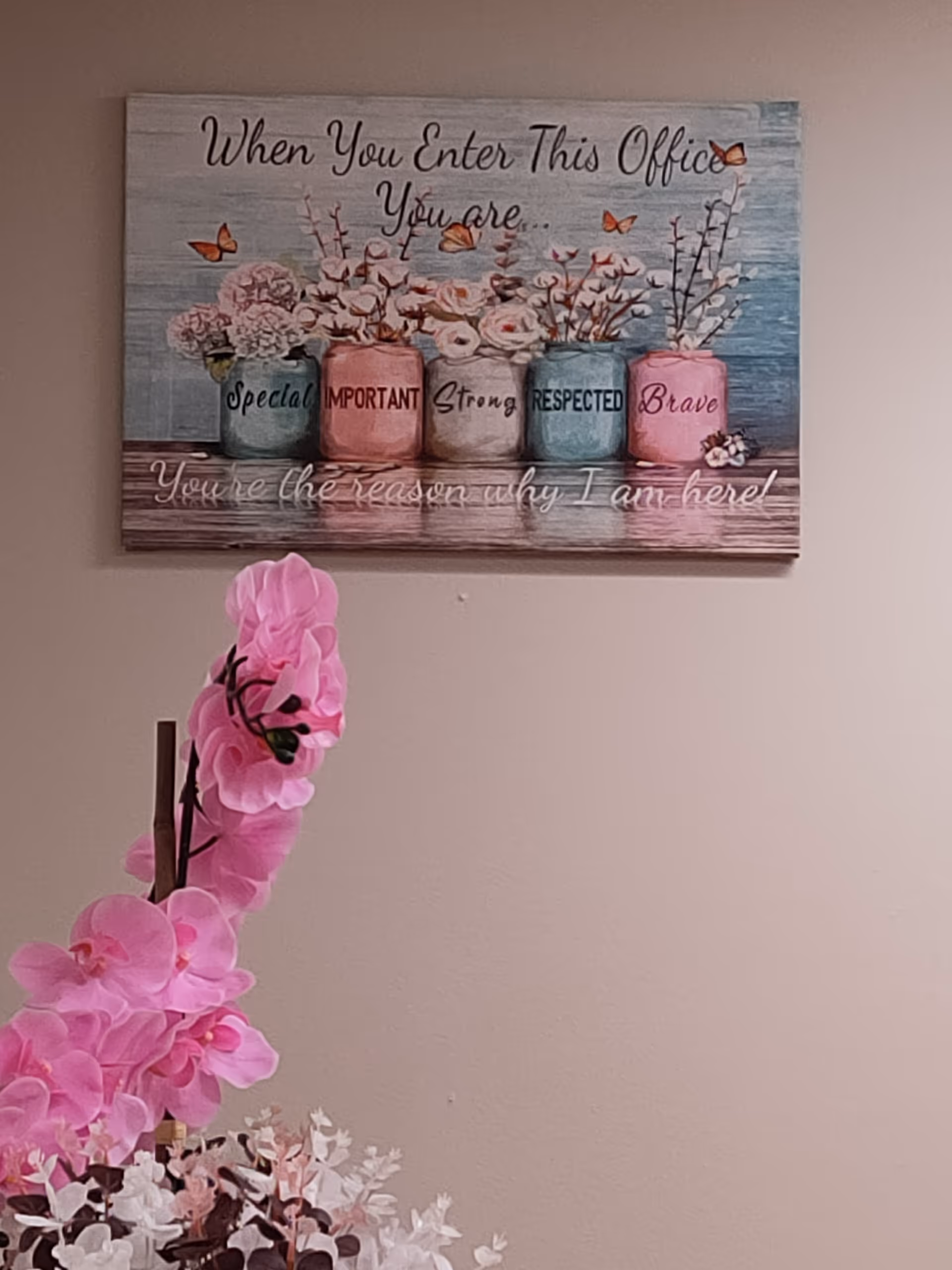Interior scene featuring wall art and a pink orchid arrangement.