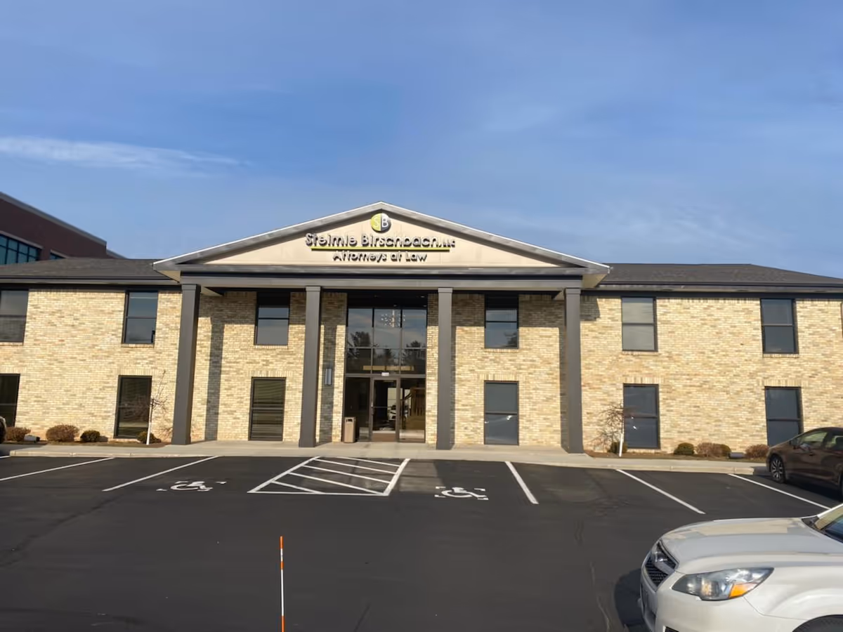 Front view of a brick senior home care building with parking