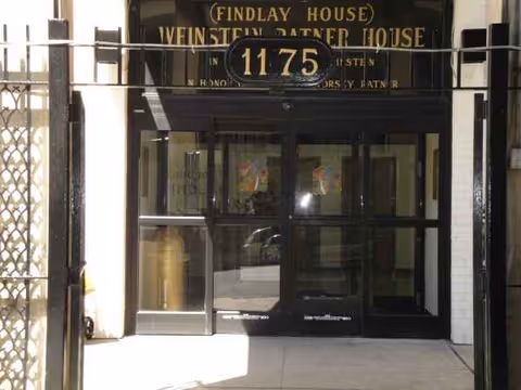 Front entrance of a building with glass doors and a sign above.
