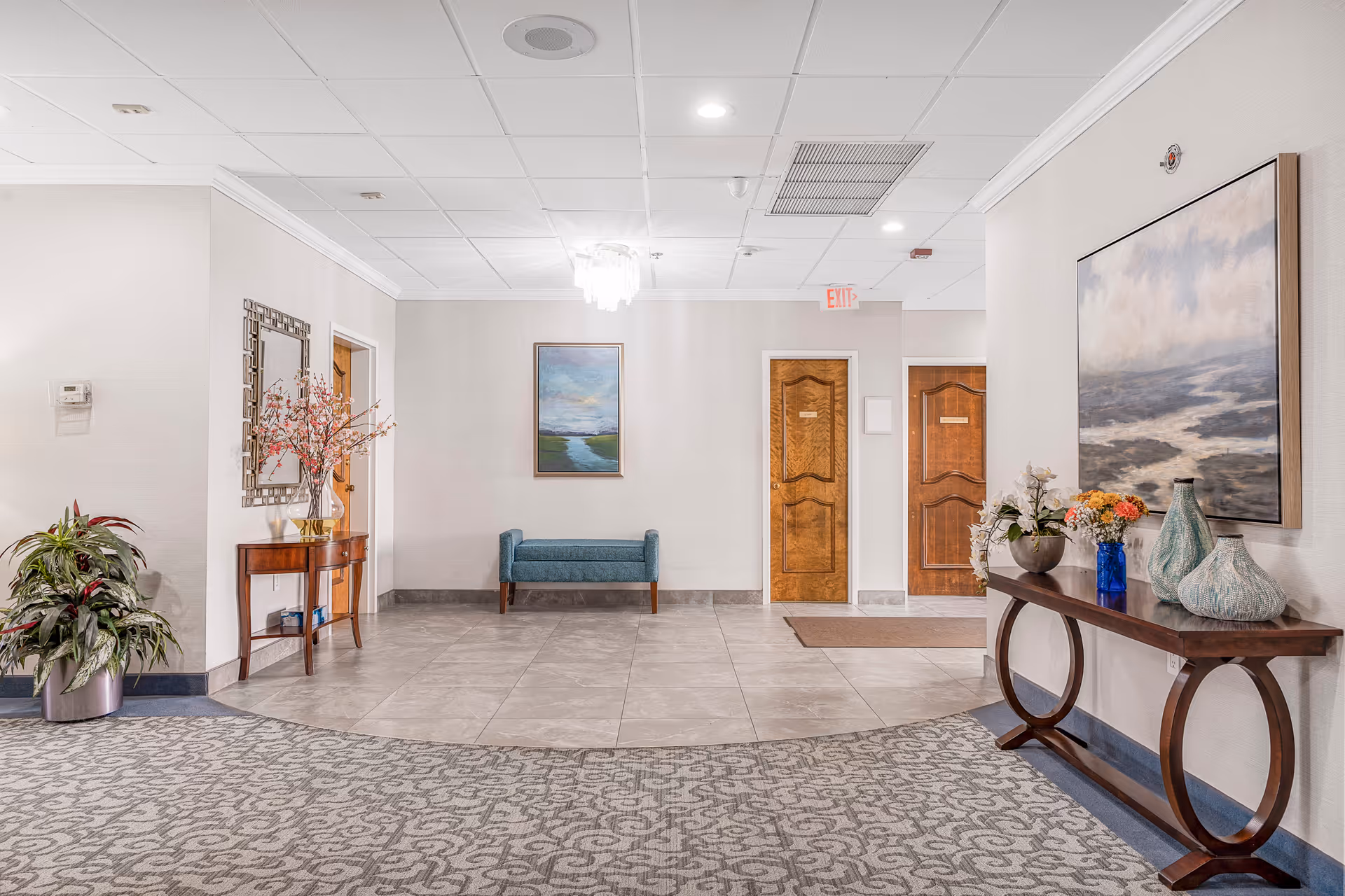 Lobby area of Carriage Hill Bethesda Health & Rehab with doors, seating, and art.