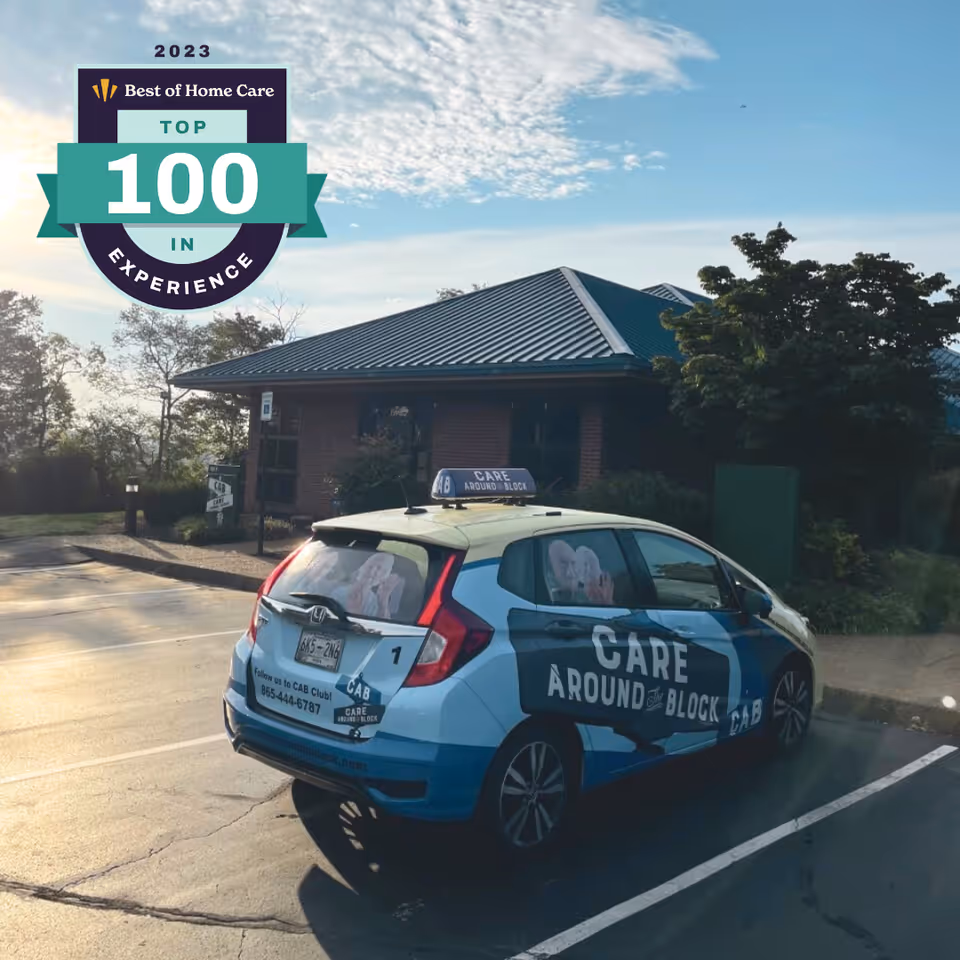 Exterior view of a care facility with a branded car parked in front.