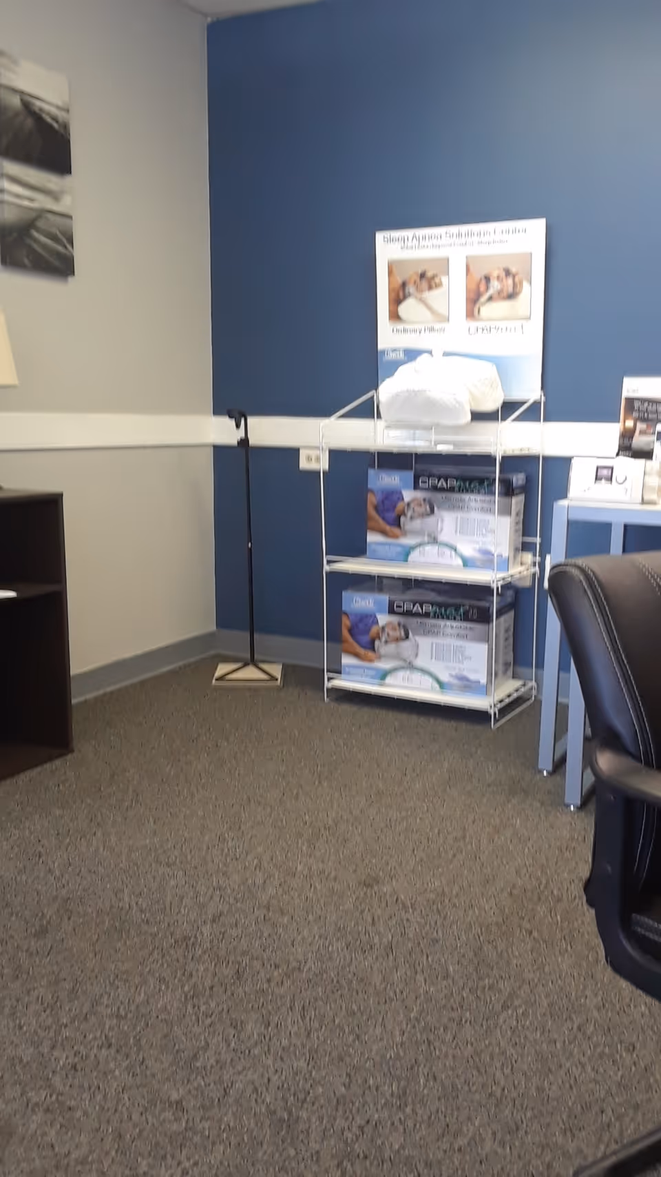 Interior office area with blue wall, equipment rack, and office chair.