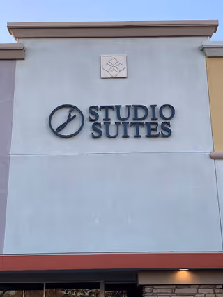 Exterior building facade with a large Studio Suites sign on the front wall.