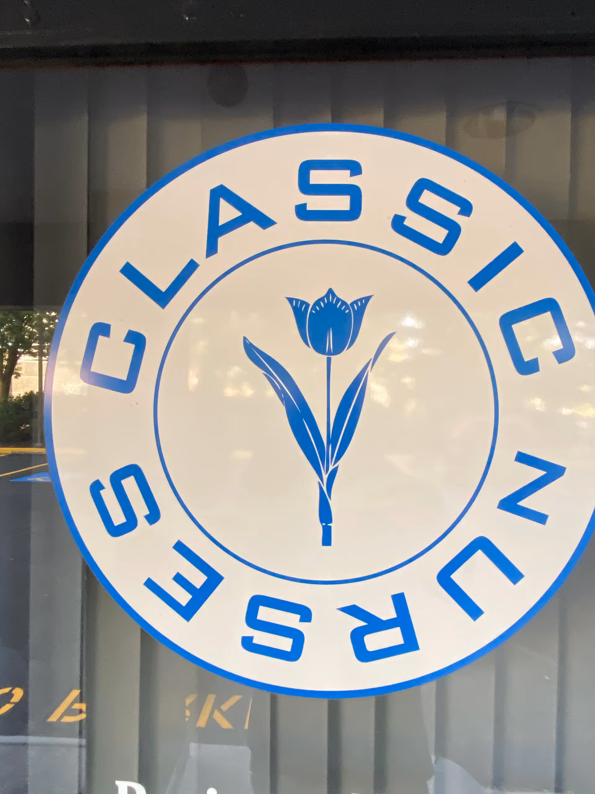 Circular blue sign on building window reads Classic Nursing Services Inc with tulip emblem.