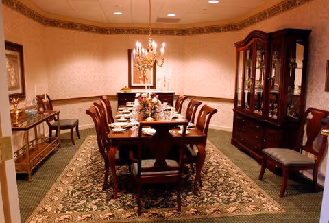 Eastman House dining room with a long table, chandelier, and glass china cabinet.