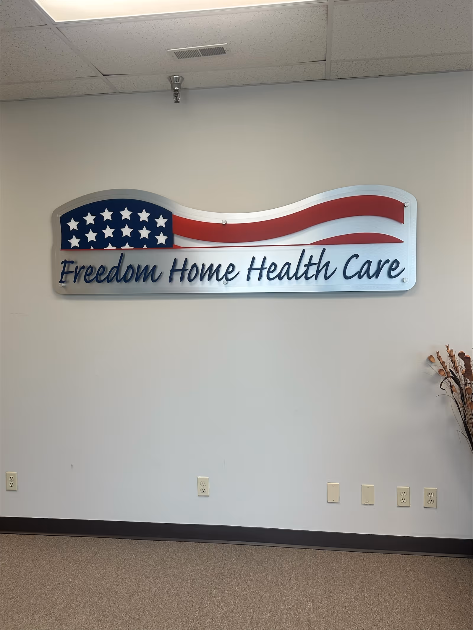 Interior wall displays a Freedom Home Health Care sign with a waving American flag.