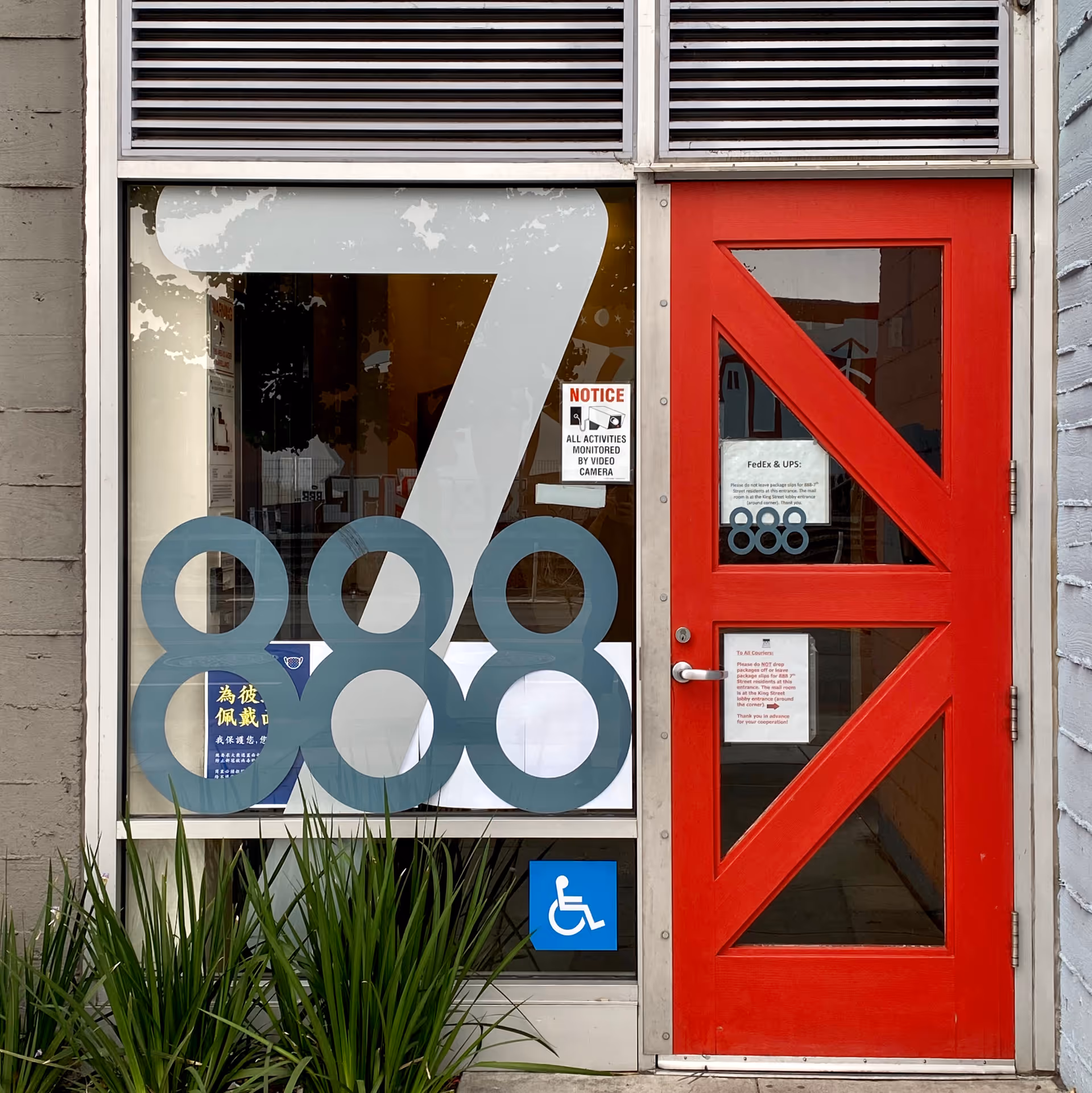 Red door beside a large window with blue 888 graphics and a wheelchair sign