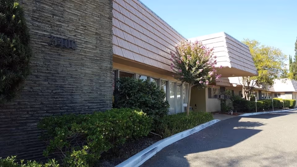 Exterior view of Arden Park Post Acute with shrubs, walkway, and tiled roof.