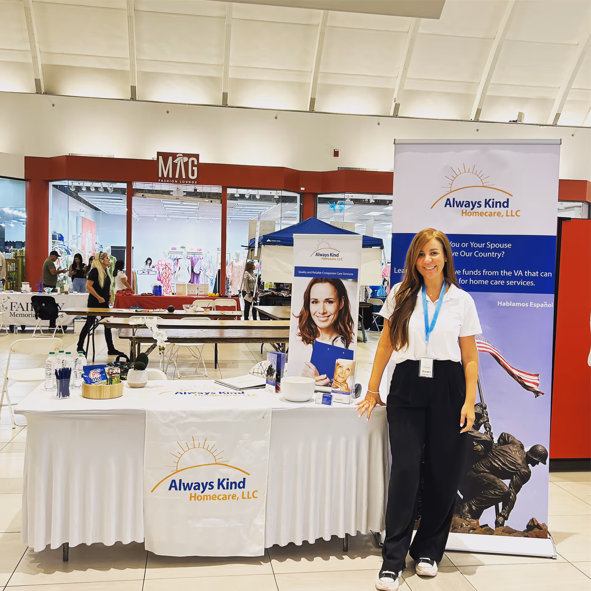 Promotional Always Kind Homecare booth in mall with a smiling staff member.