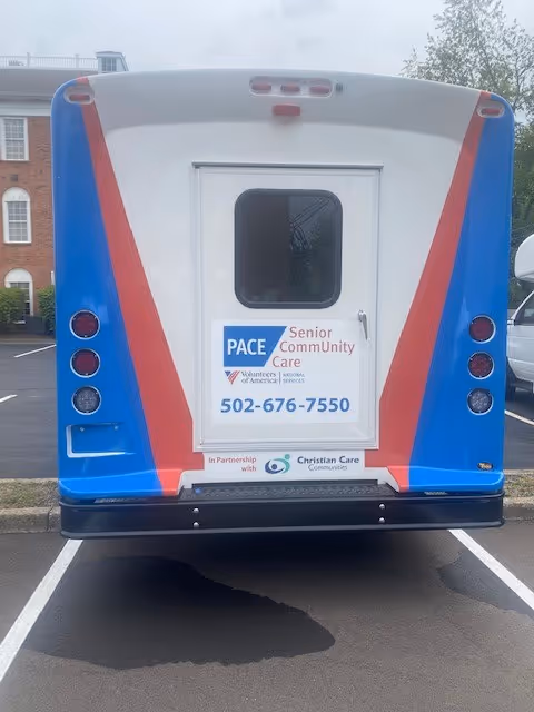Rear view of a blue and white PACE Senior CommUnity Care bus.