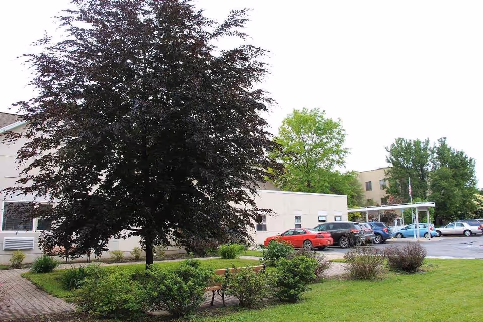 Exterior view of a building with a parking lot and landscaped greenery.