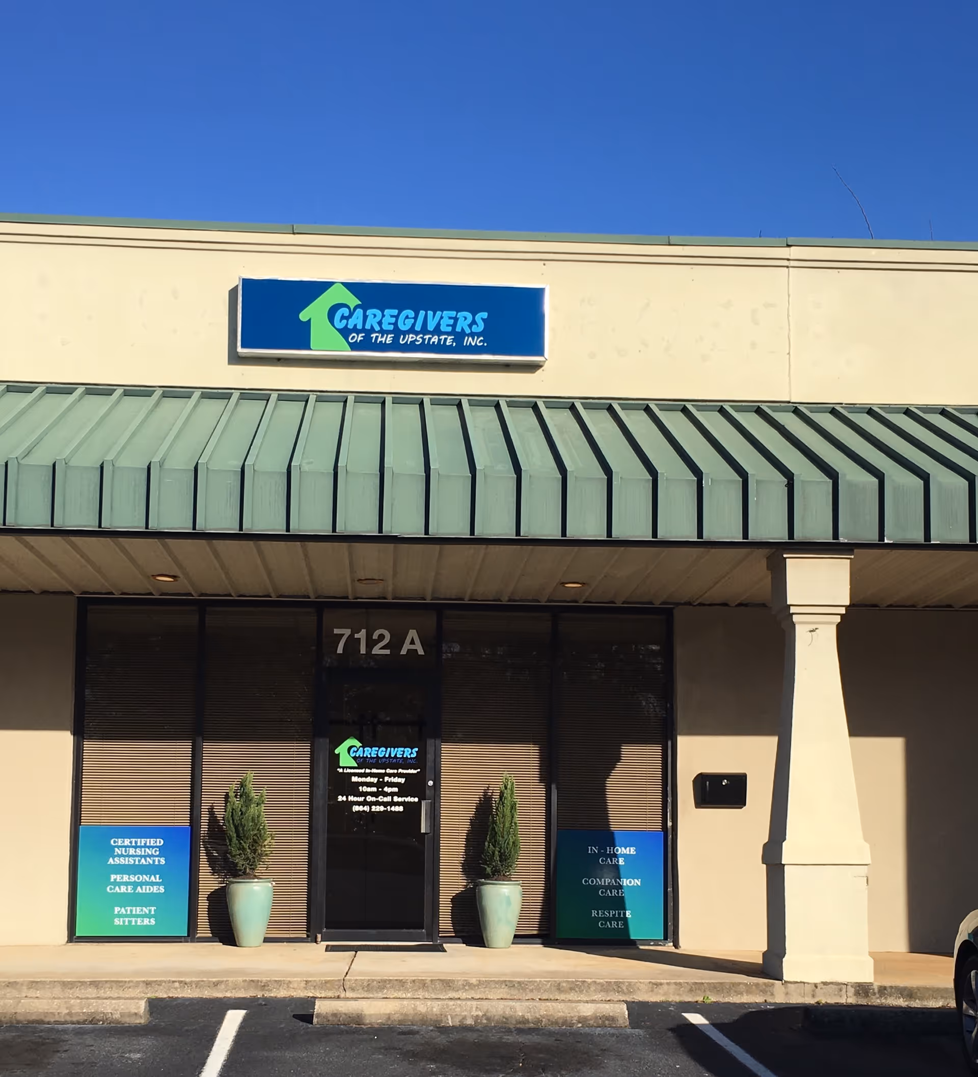 Exterior view of Caregivers of the Upstate facility storefront with entrance and potted plants