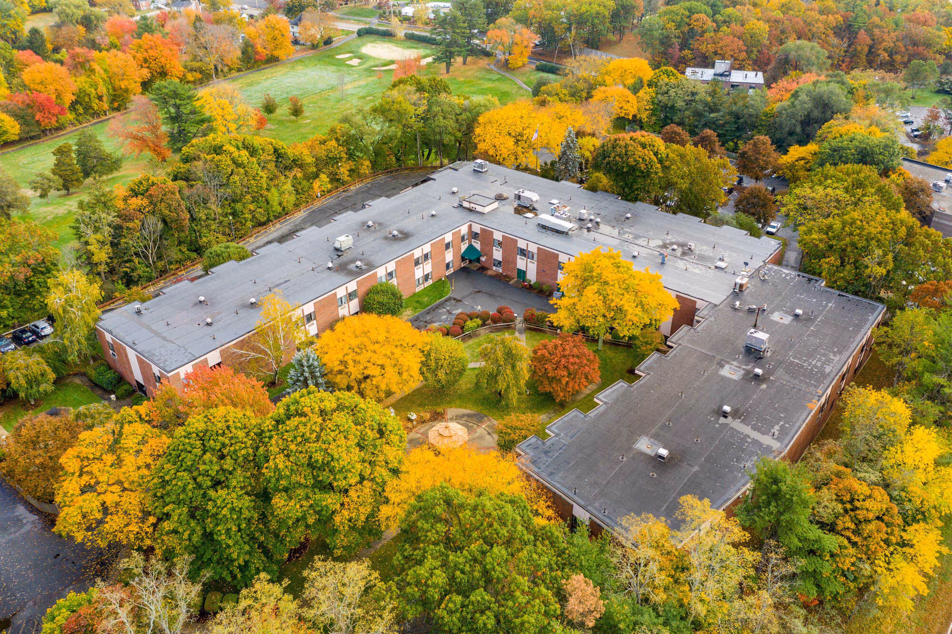 Aerial view of Bear Hill Nursing Center at Wakefield surrounded by autumn trees.