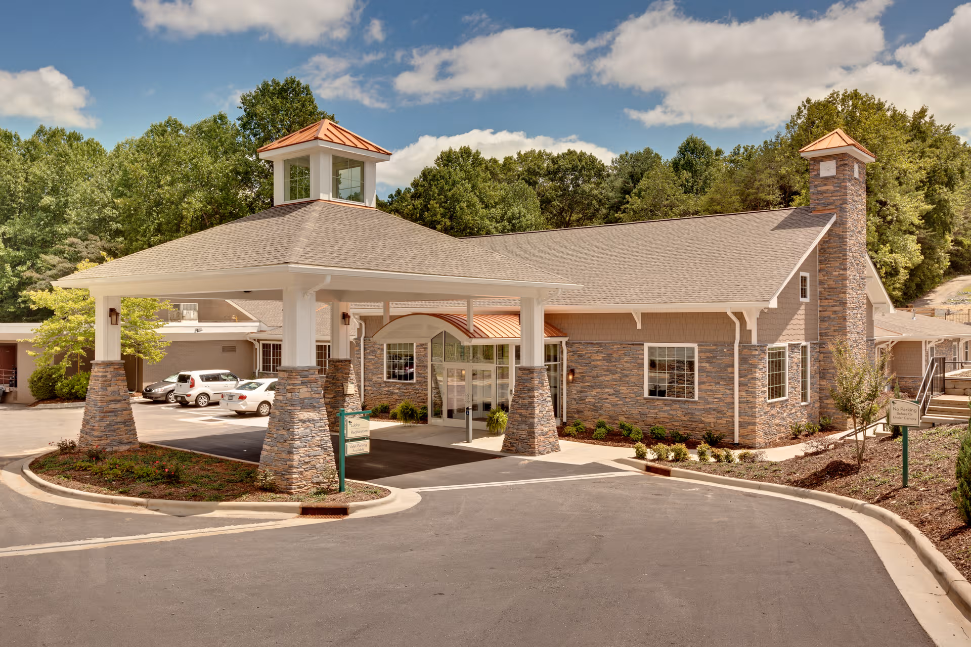 Exterior view of PruittHealth - Elkin facility with porte-cochere and stone pillars.