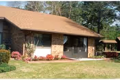 Front view of a single-story brick Air Force Enlisted Village building with entry doors.