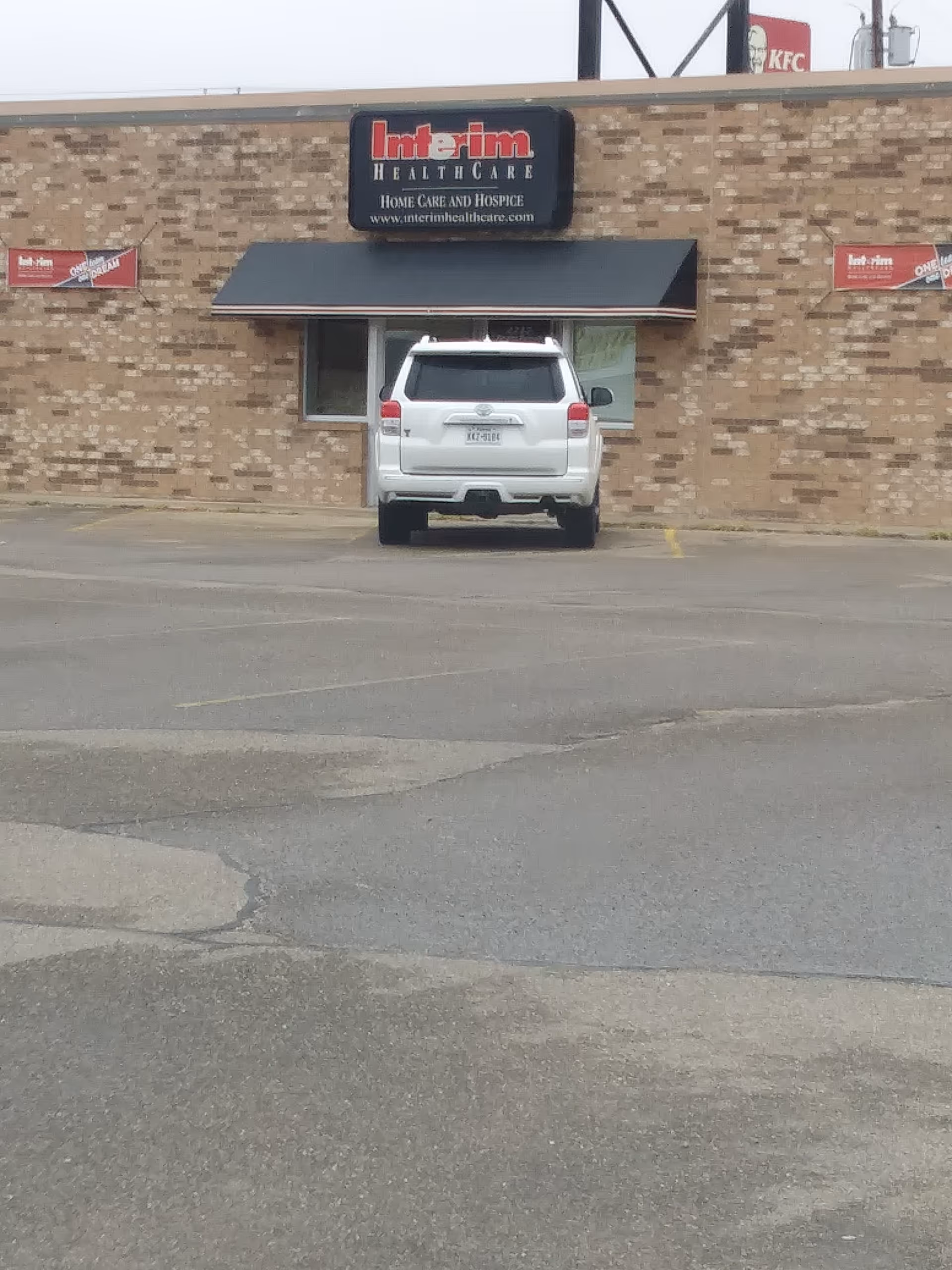Exterior view of Interim HealthCare of Pampa building with a white SUV parked in front.