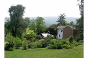 Exterior view of the Lutheran Home at Hollidaysburg with a grassy yard and trees.