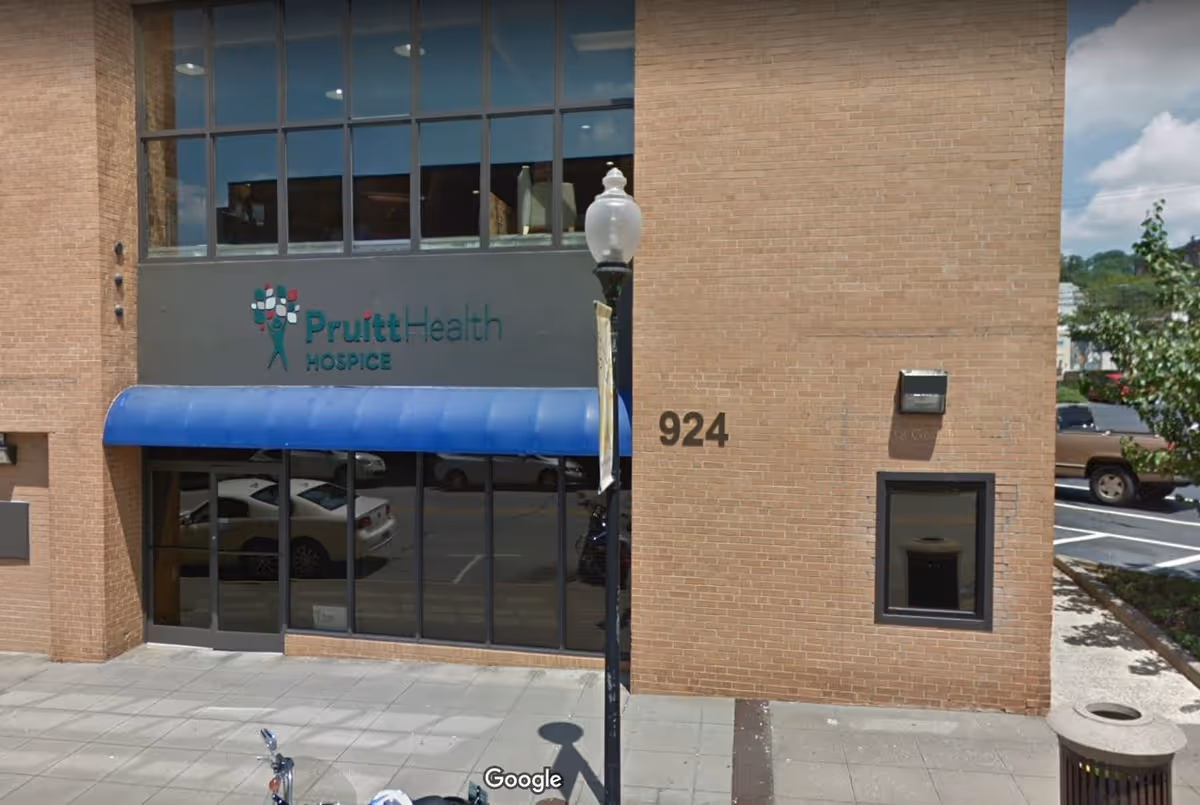Exterior view of PruittHealth Hospice building front with blue awning over entrance.