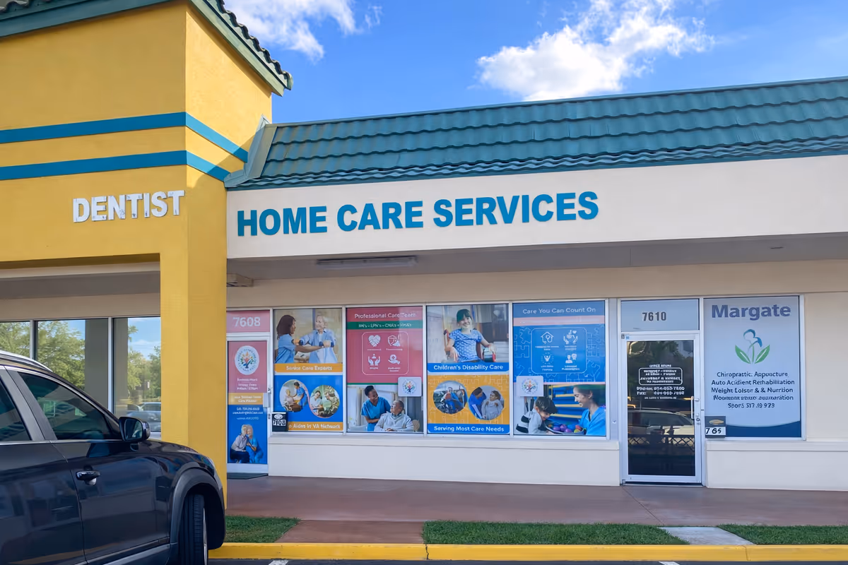 Exterior storefront with Home Care Services signage, a dentist sign, window posters, and a parked car.