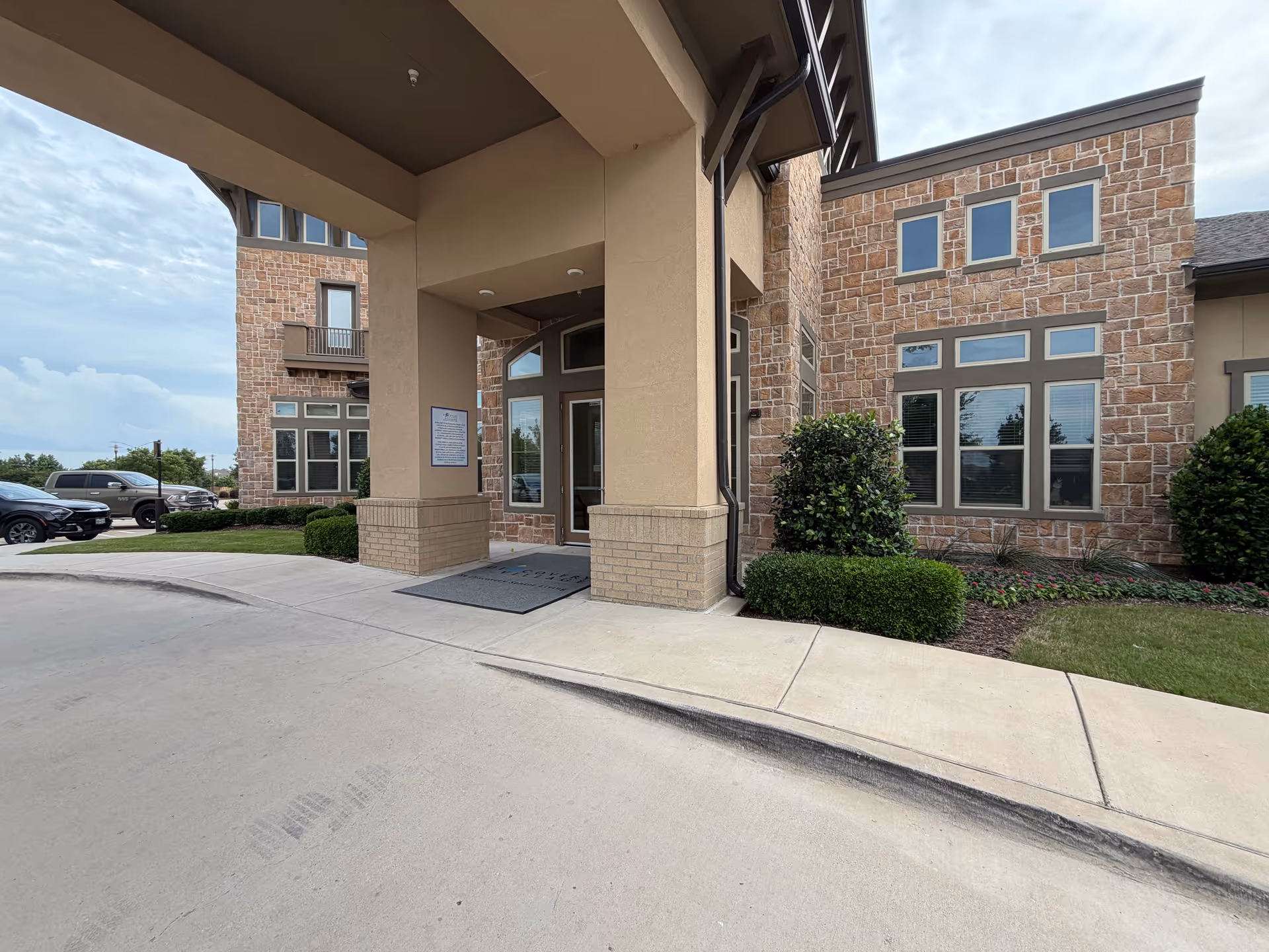 Entrance to Discovery Village at Alliance Town Center with brick exterior and covered entry.