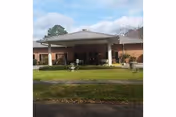 Exterior view of Courtyard Retirement & Assisted Living Community entrance with a covered drop-off area.